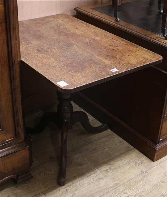 A Regency mahogany tripod table, the rectangular tilting top on a baluster-turned shaft and tripartite base W.59cm